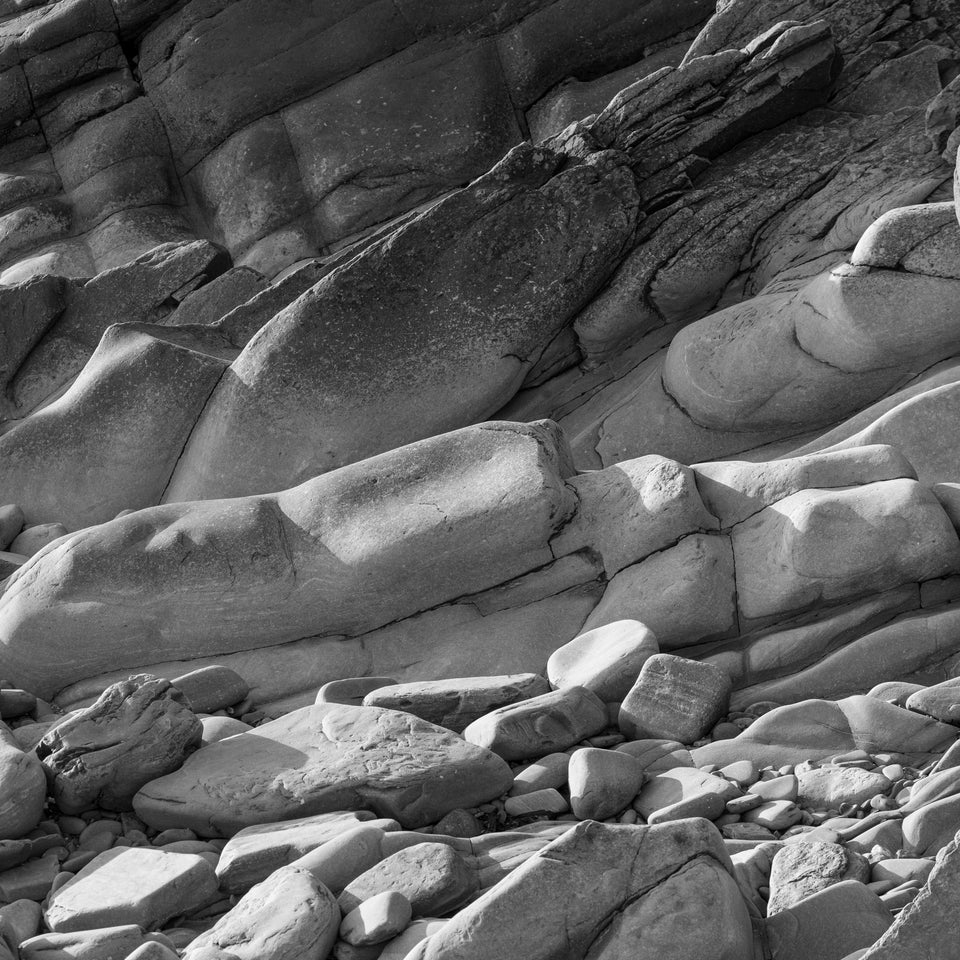 Black and white photograph of sea-smoothed rocks on the shore at Hoswick, Shetland