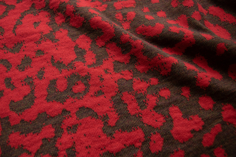 Swatch of a marlet jumper, knitted in fine merino in a mottled animal print. tomato red and chestnut brown.