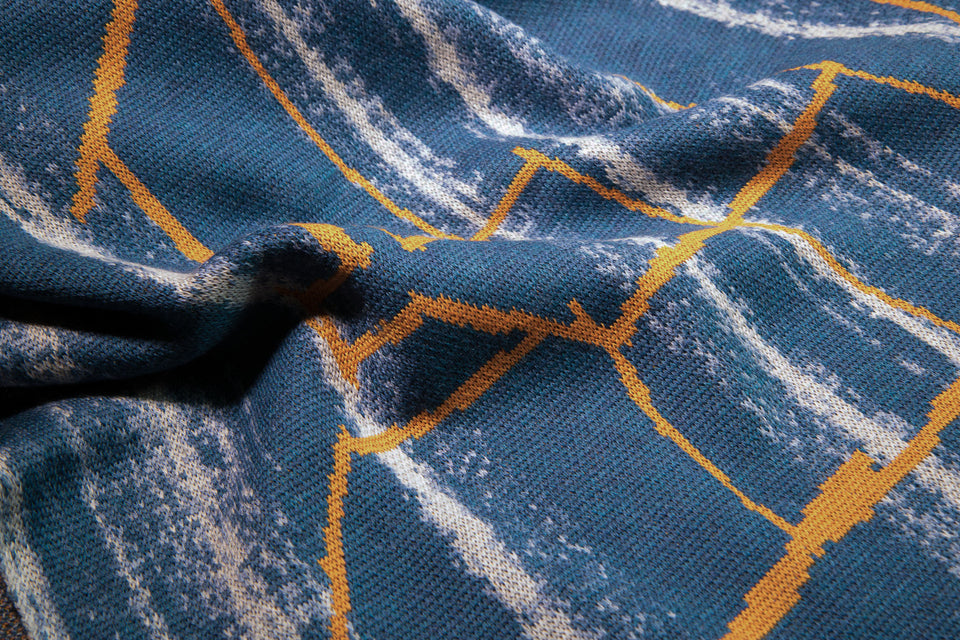 close up detail of knitted cape in blues with orange highlight, by Nielanell contemporary knitwear Shetland