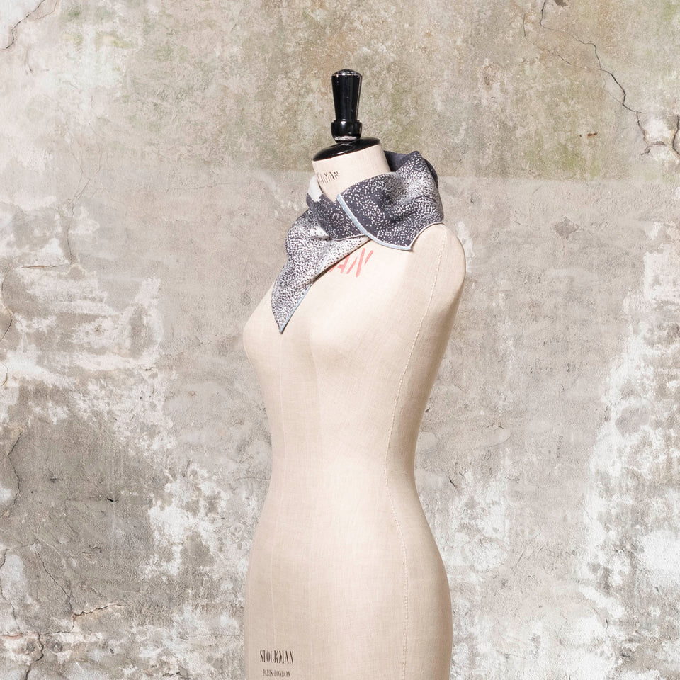 Knitted Byre cowl. Abstract, graphic design in an asymmetric shape. Shown in Charcoal and stone white