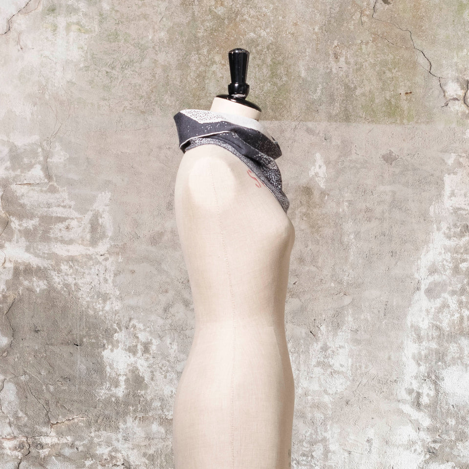 Knitted Byre cowl. Abstract, graphic design in an asymmetric shape. Shown in Charcoal and stone white