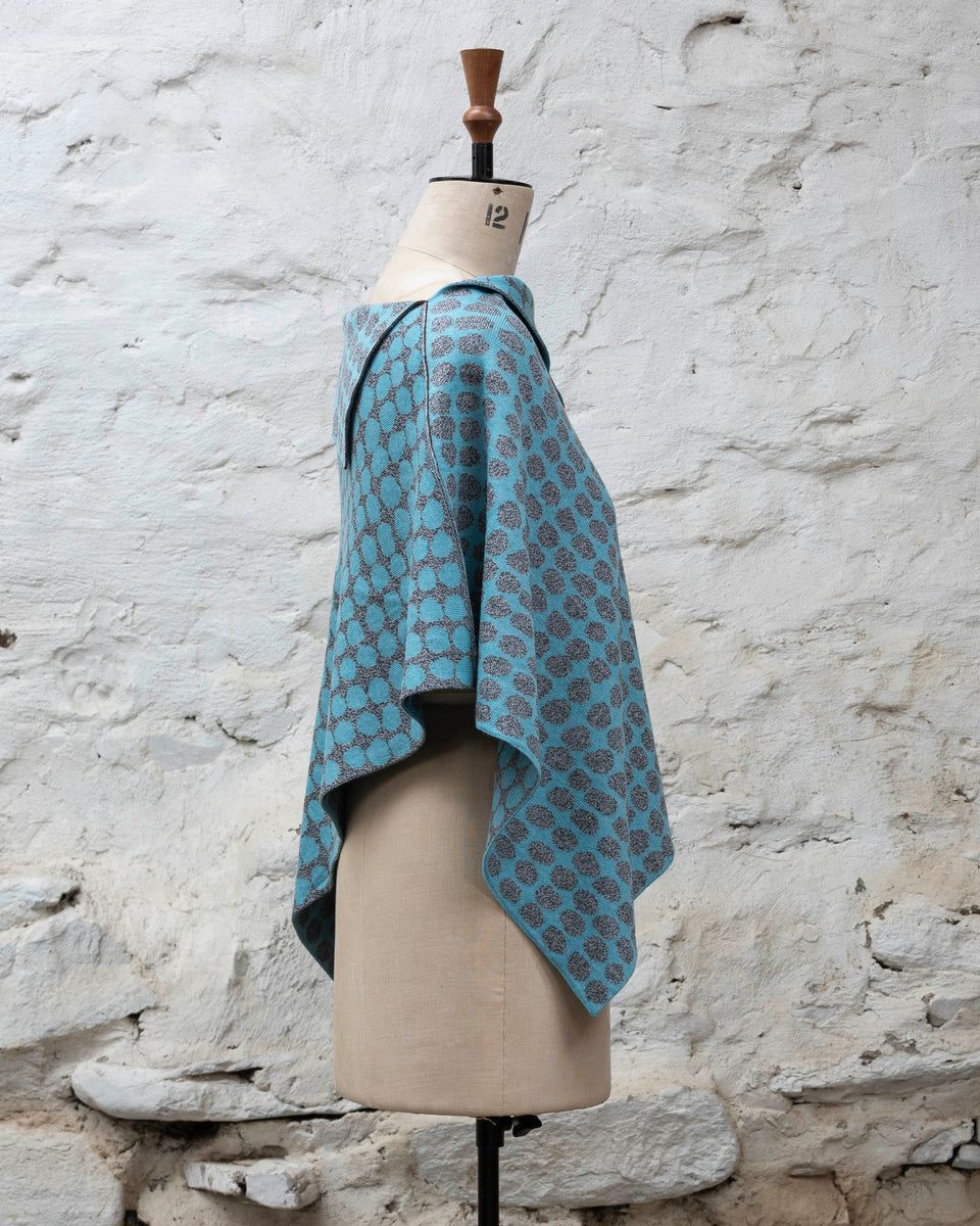 Knitted cape with an irregular dot design in two colours. Show in pale blue and marled grey
