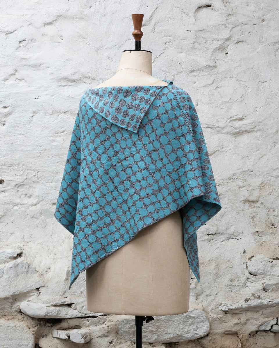 Knitted cape with an irregular dot design in two colours. Show in pale blue and marled grey