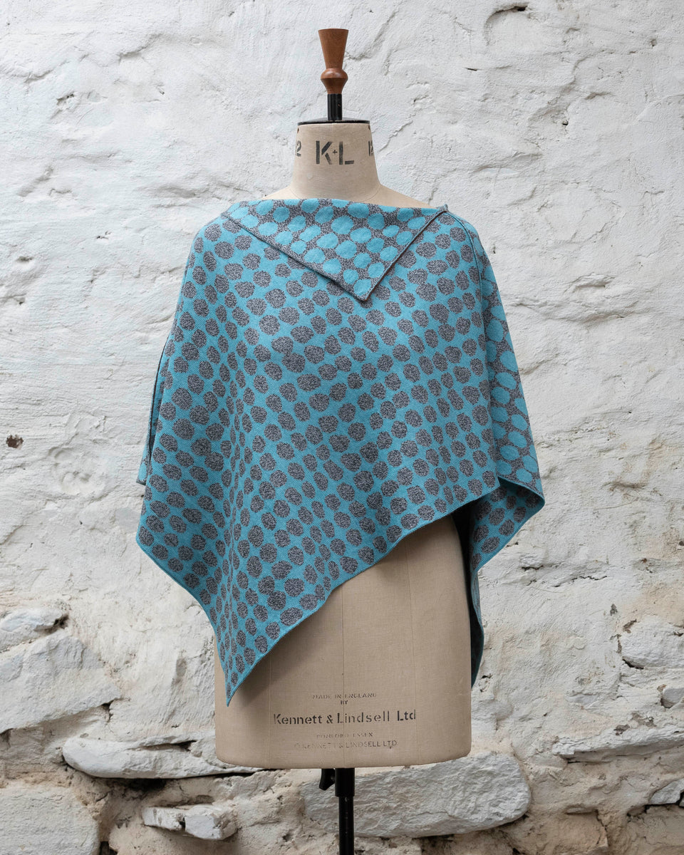 Knitted cape with an irregular dot design in two colours. Show in pale blue and marled grey