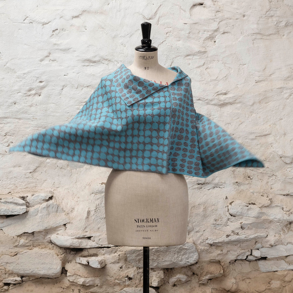 Knitted cape with an irregular dot design in two colours. Show in pale blue and marled grey