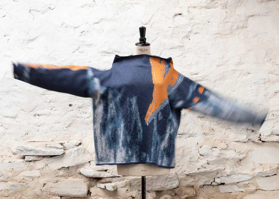 Modern Scottish statement knitwear. Wearable art, this jumper features a motif derived from drawings in Hoswick. Abstract textures in sea blues with orange highlights