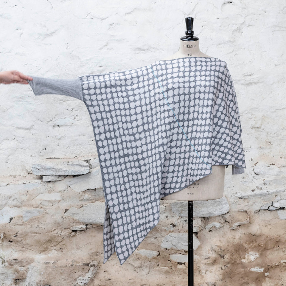 knitted asymmetric jumper with an irregular dot pattern. Showin in off white and greys