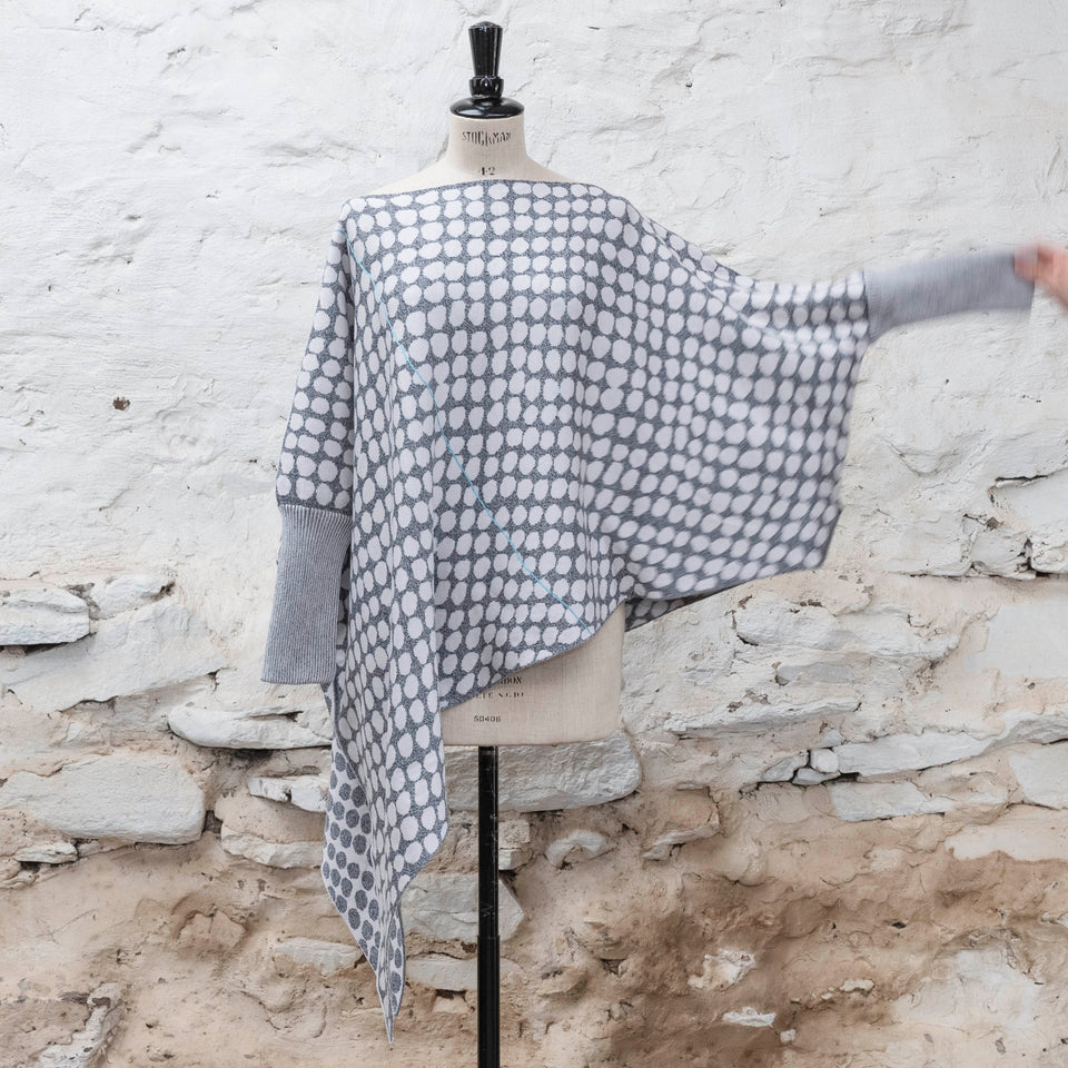 knitted asymmetric jumper with an irregular dot pattern. Showin in off white and greys