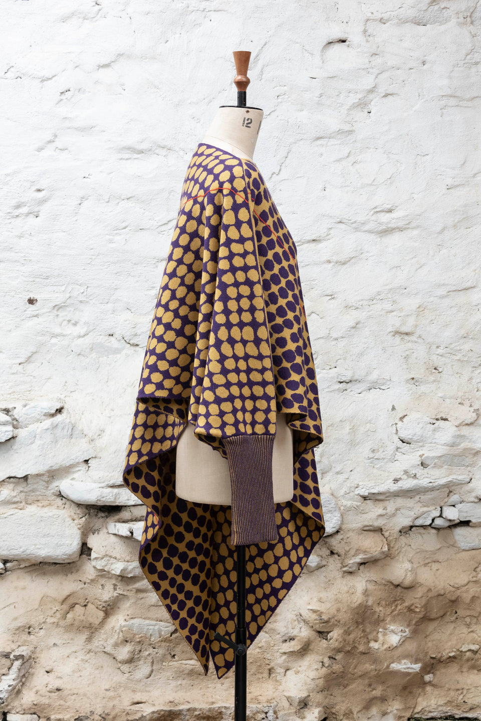 knitted asymmetric jumper with an irregular dot pattern. Shown in gold and aubergine
