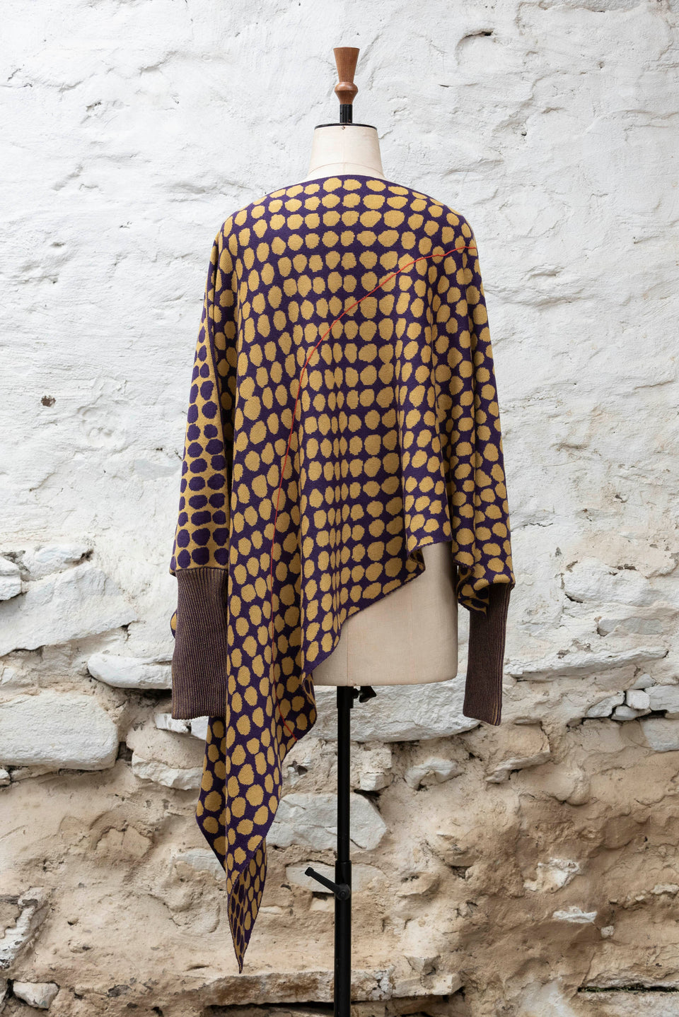 knitted asymmetric jumper with an irregular dot pattern. Shown in gold and aubergine