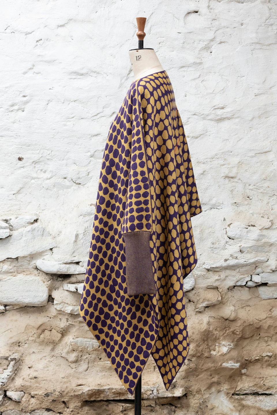 knitted asymmetric jumper with an irregular dot pattern. Shown in gold and aubergine