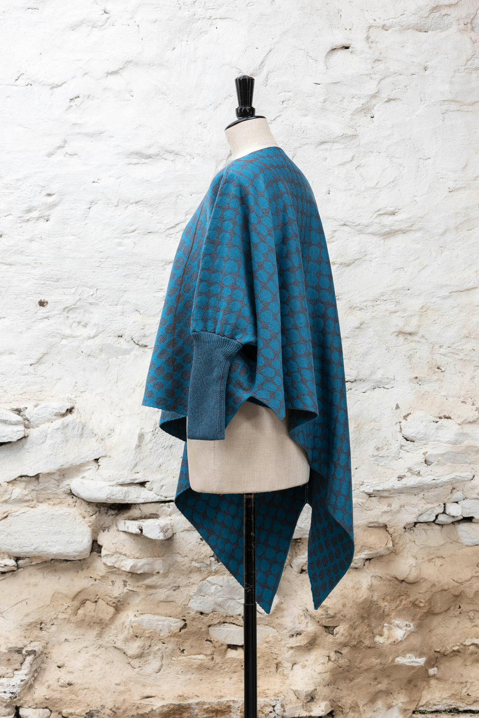 knitted asymmetric jumper with an irregular dot pattern. Shown in blues