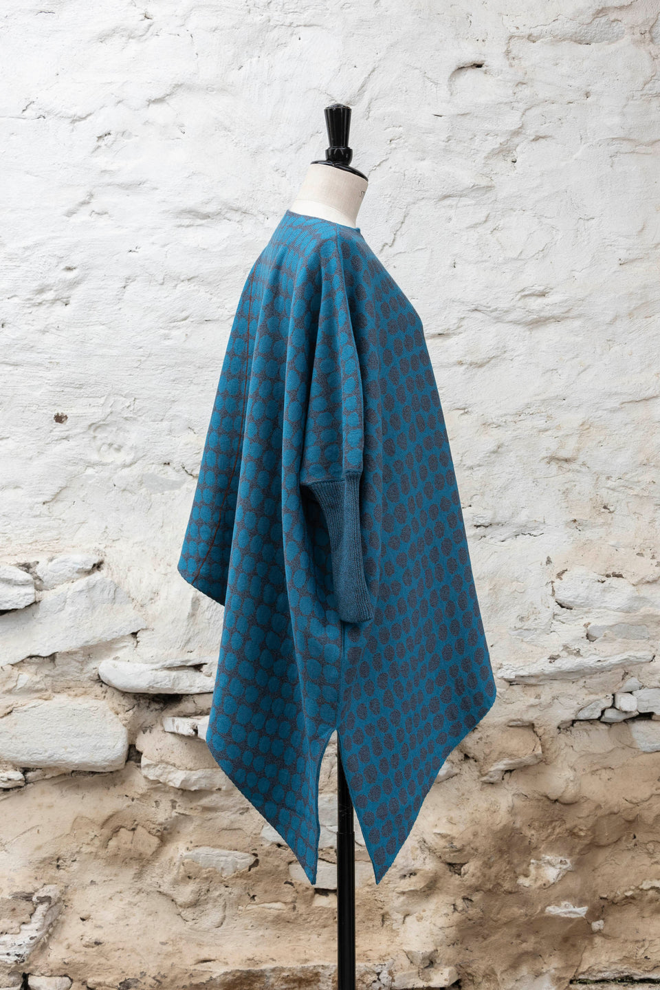 knitted asymmetric jumper with an irregular dot pattern. Shown in blues