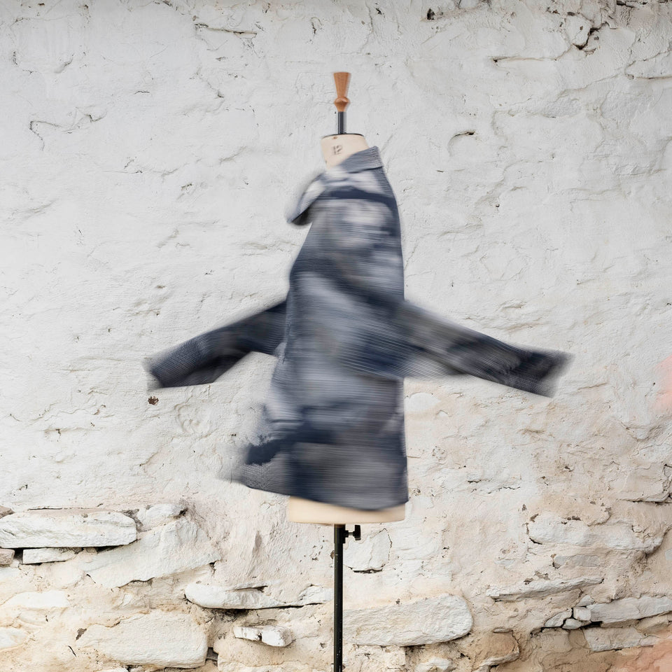 Knitted Rani jumper. Small abstract patterns make up a larger design with photographic imagery. Shown in inky blue and antique white