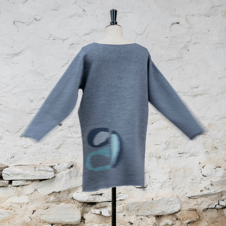 Knitted sleevletunic in blues with accents in aqua. The pattern is abstract