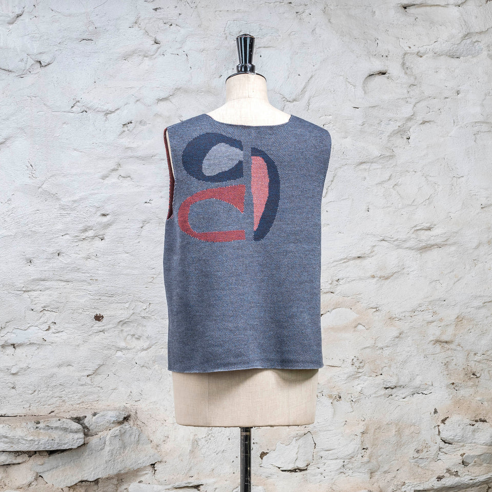 Knitted sleevless tanque in blues with accents in coral. The pattern is abstract