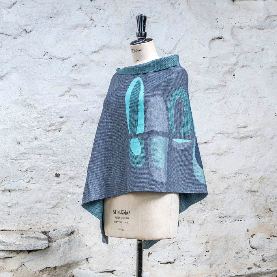 Knitted cape in blues with accents in aqua. The pattern is abstract