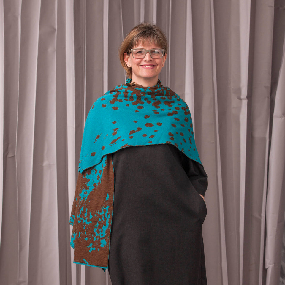 Knitted marlet wrap. Mottled animal print design show in in aqua and bronze