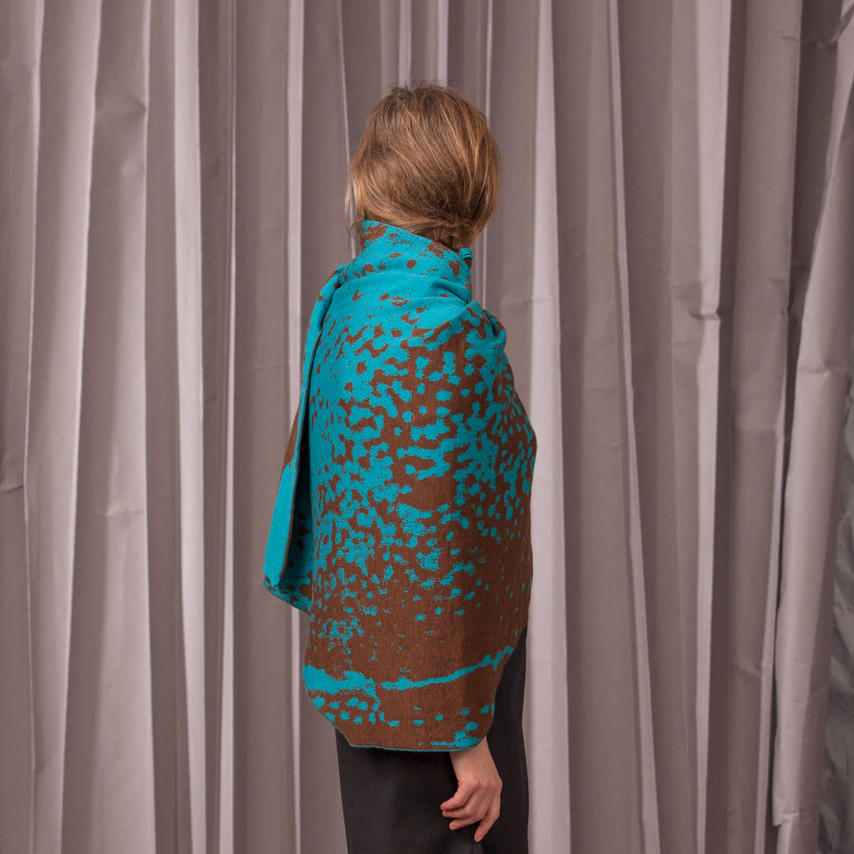Knitted marlet wrap. Mottled animal print design show in in aqua and bronze