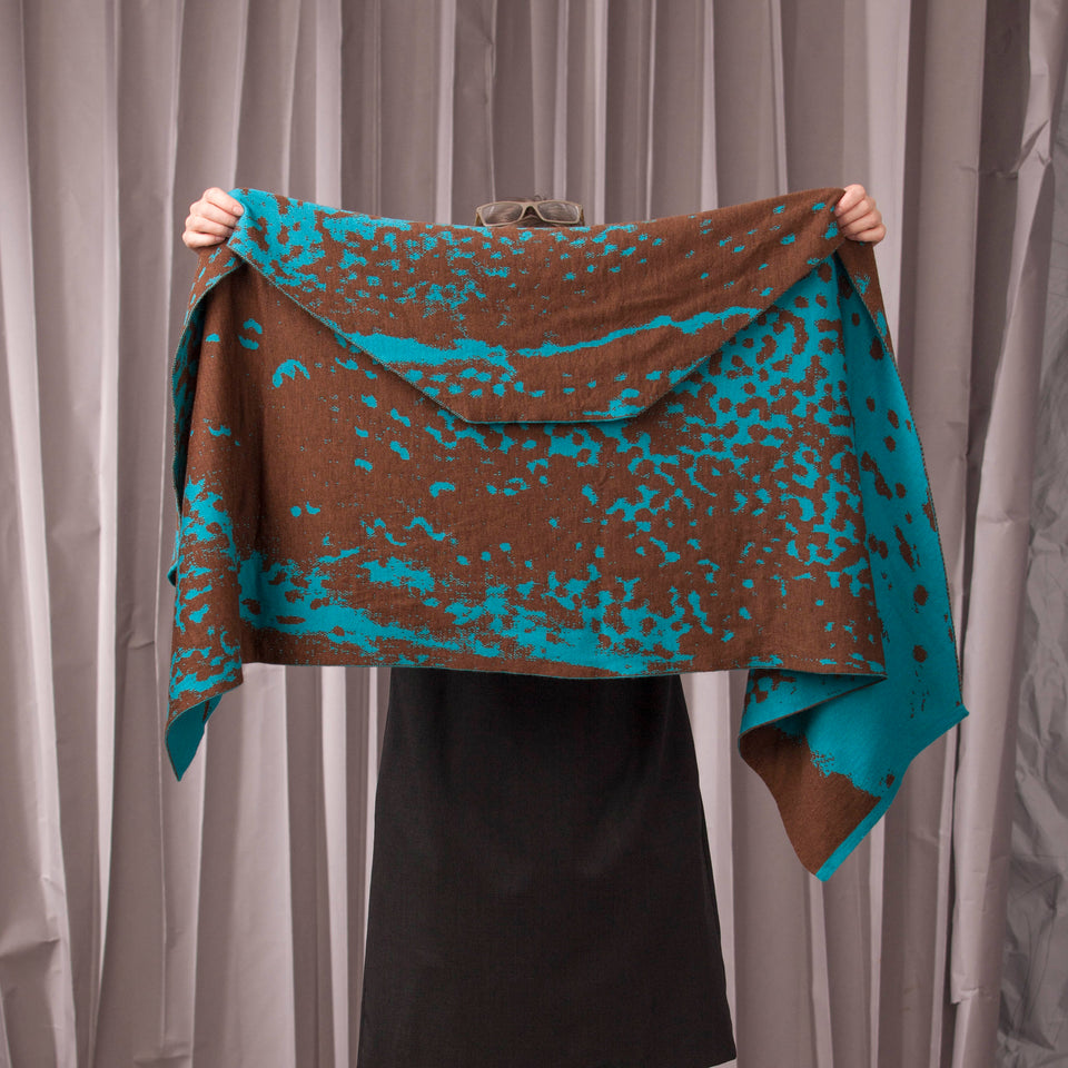 Knitted marlet wrap. Mottled animal print design show in in aqua and bronze