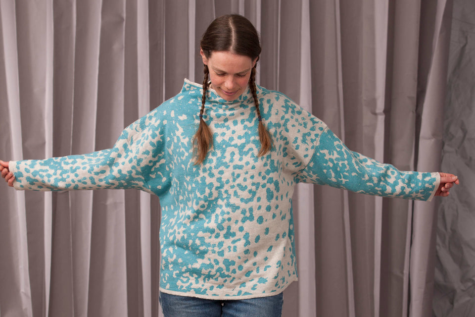 Knitted marlet jumper. Mottled animal print abstract pattern shown in turquoise and white