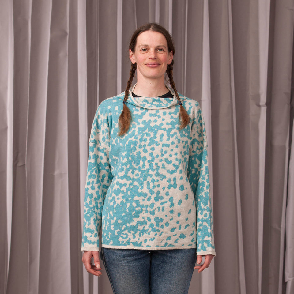 Knitted marlet jumper. Mottled animal print abstract pattern shown in turquoise and white