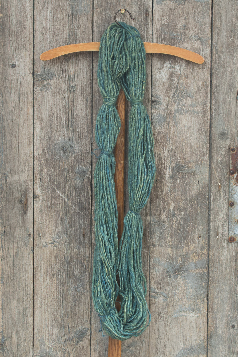 handspun, hand-dyed indigo art yarn. shetland wool, linen, tussah silk shown in a hank