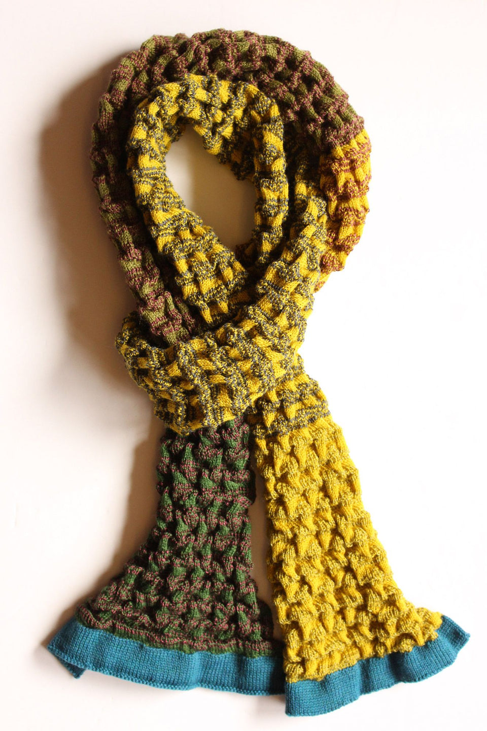 Rigg scarf. Ridged textile in stripes and colour blocks. Show in golds and nice blue