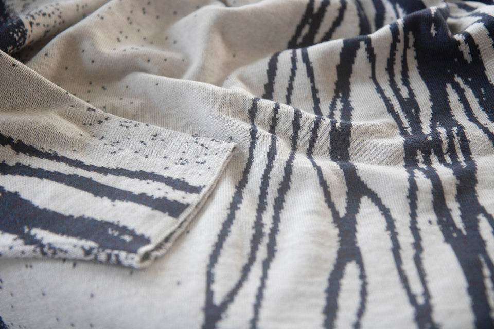 swatch of shoormal jumper showing the side with pattern in smooky blue on off-white. the blue yarn is actually a marl of mocha and blue.