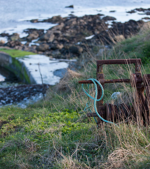 Looking down onto the pier at Hoswick, Shetland. An old bit of rusty winding gear sits in the foreground