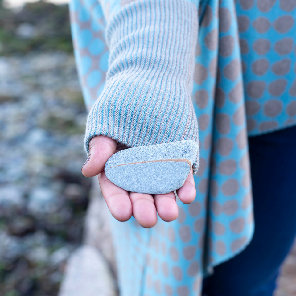 Detail of the long ribbed cuff of the Ebb-stanes triangle jumper in soft blues and warm grey-fawns.