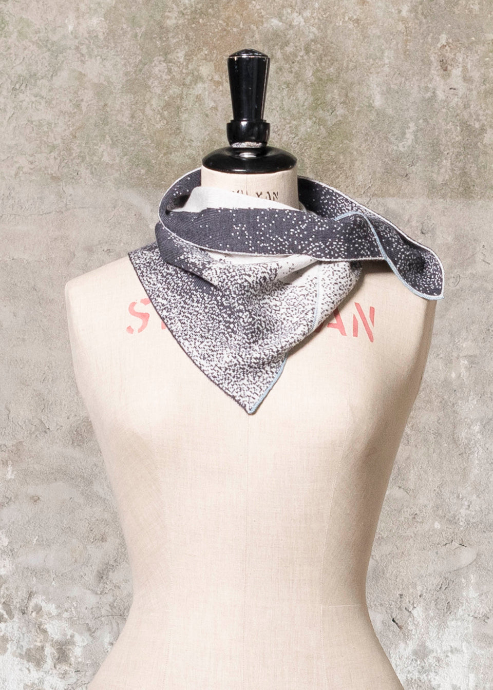 Knitted Byre cowl. Abstract, graphic design in an asymmetric shape. Shown in Charcoal and stone white