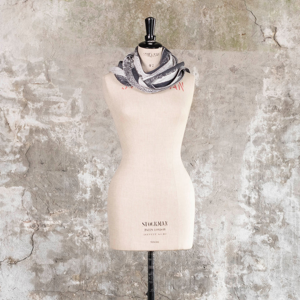 Knitted Byre scarf. Abstract, graphic design in an asymmetric shape. Shown in Charcoal and stone white