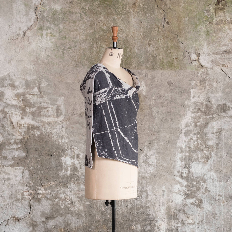 Knitted Byre capelet. Abstract, graphic design in an asymmetric shape. Shown in Charcoal and stone white
