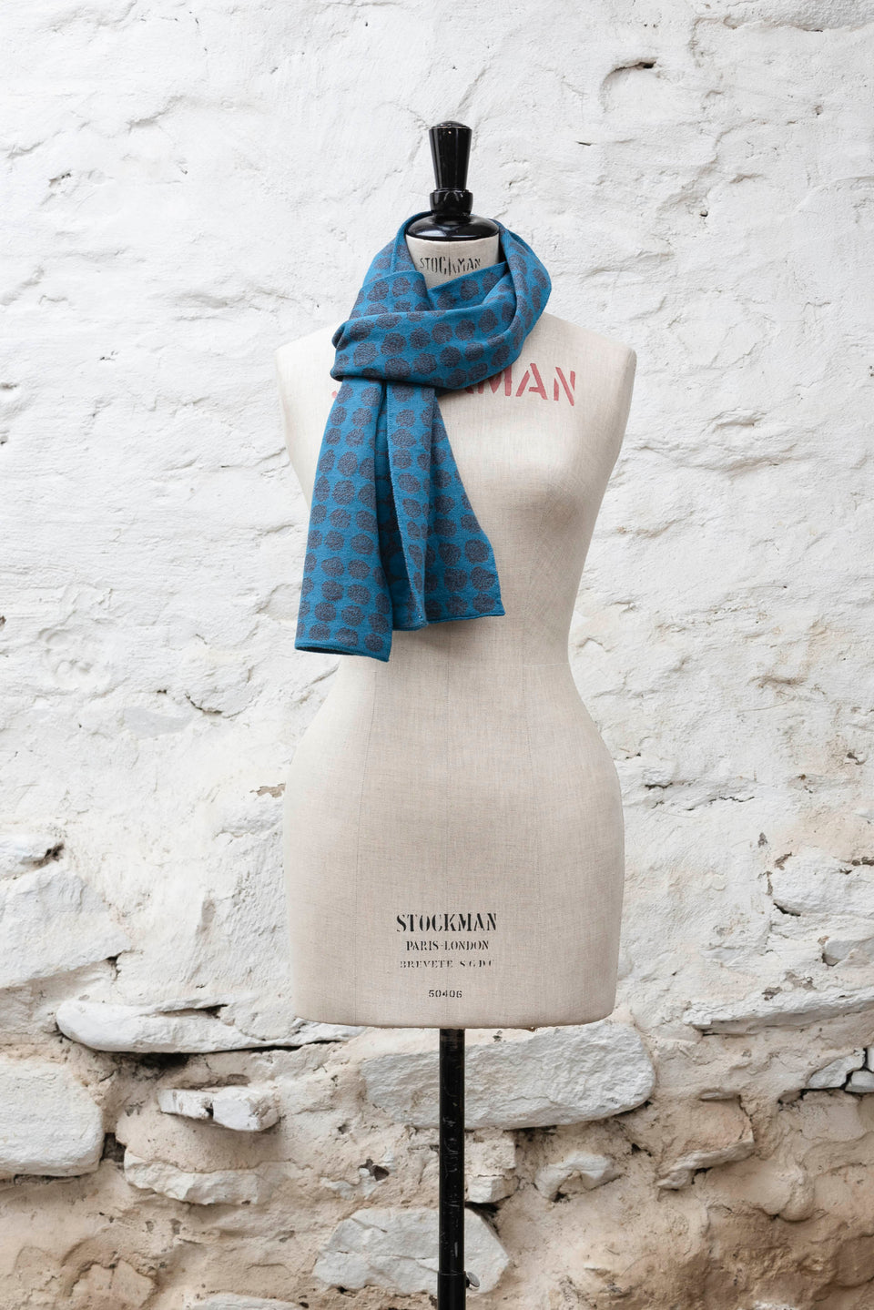 Knitted scarf with an irregular dot design in two colours. Show in blues