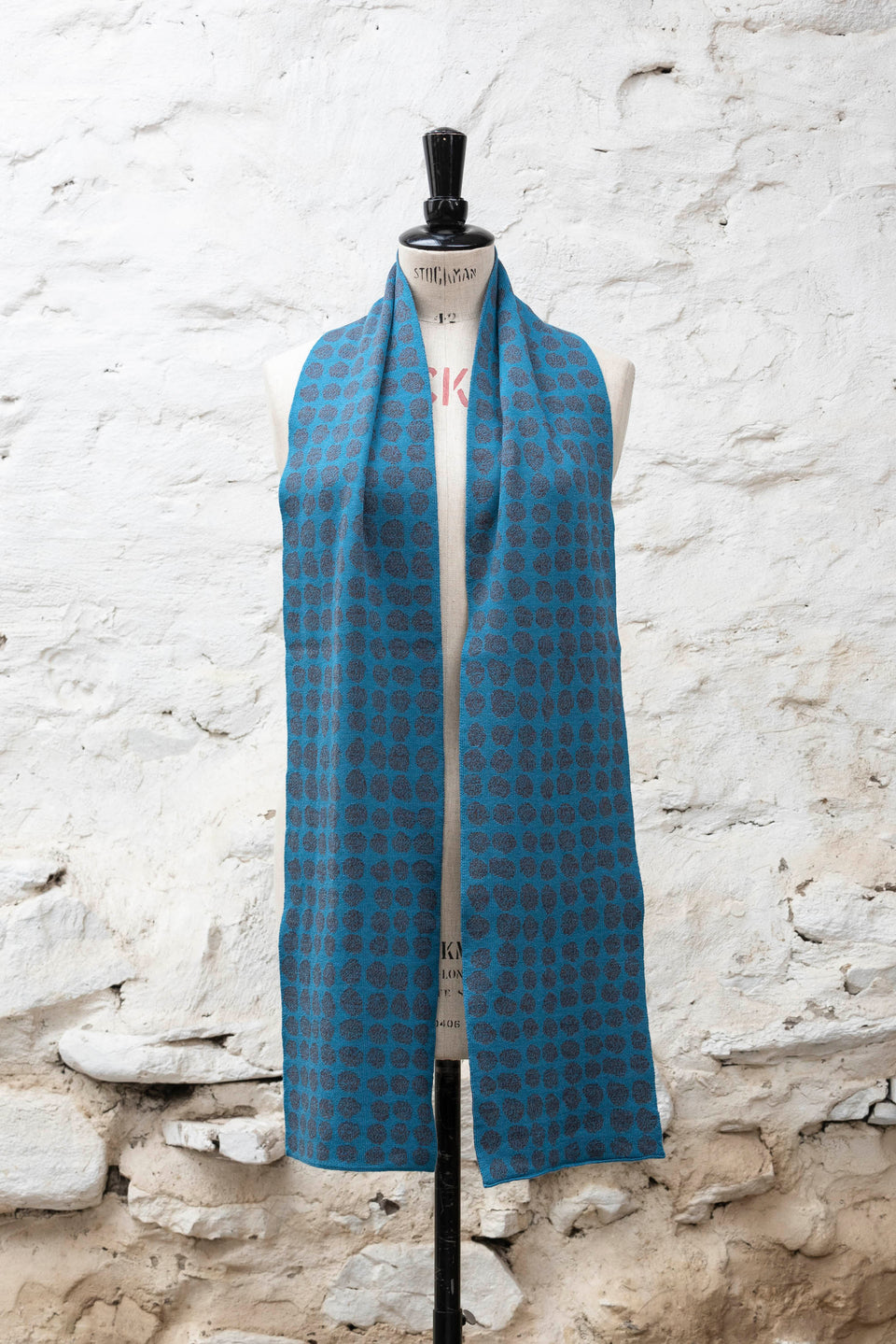 Knitted scarf with an irregular dot design in two colours. Show in blues