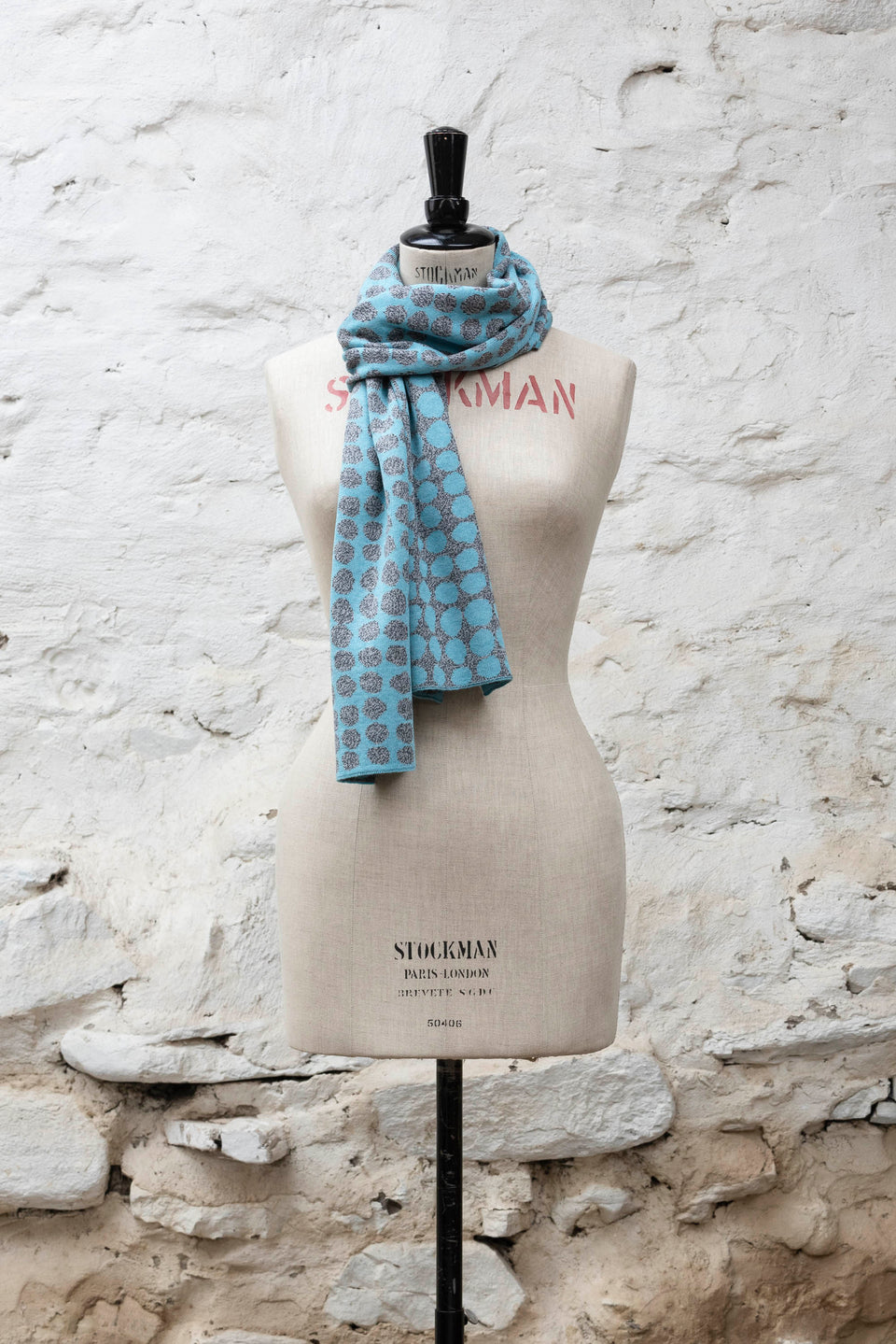 Knitted scarf with an irregular dot design in two colours. Show in light blue and greys