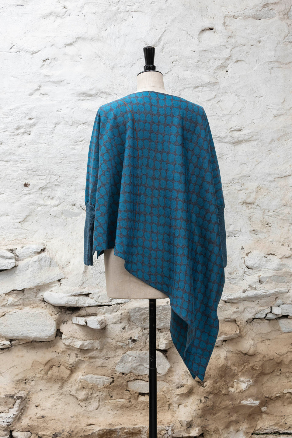 knitted asymmetric jumper with an irregular dot pattern. Shown in blues