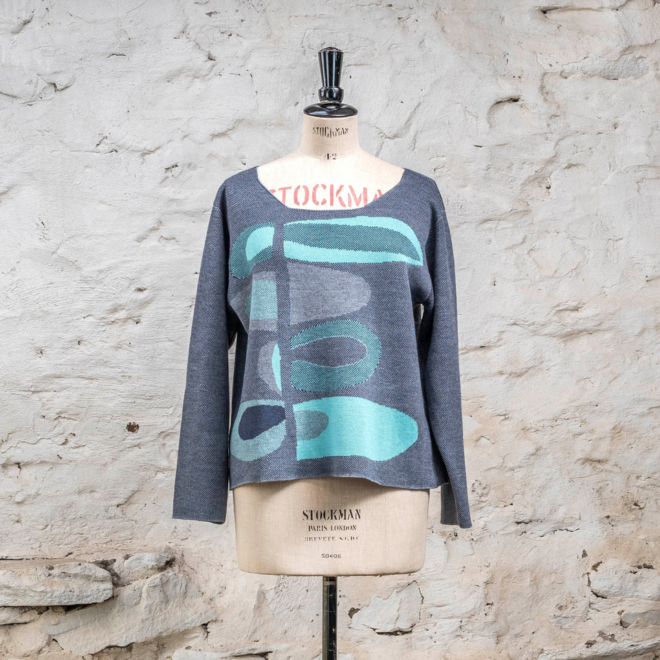 Front view of knitted 'conversation Pieces' jumper in blues with accents in aqua. The pattern is abstract