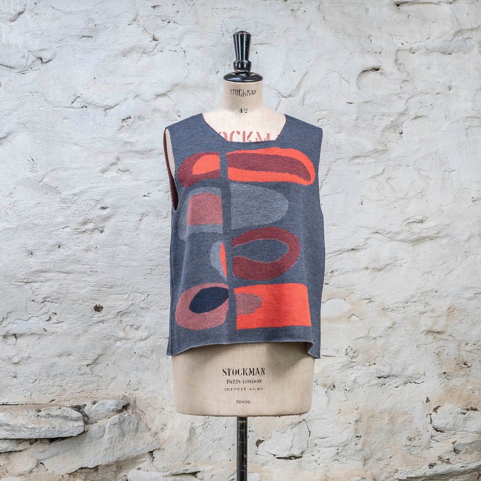 Knitted sleevless tanque in blues with accents in coral. The pattern is abstract