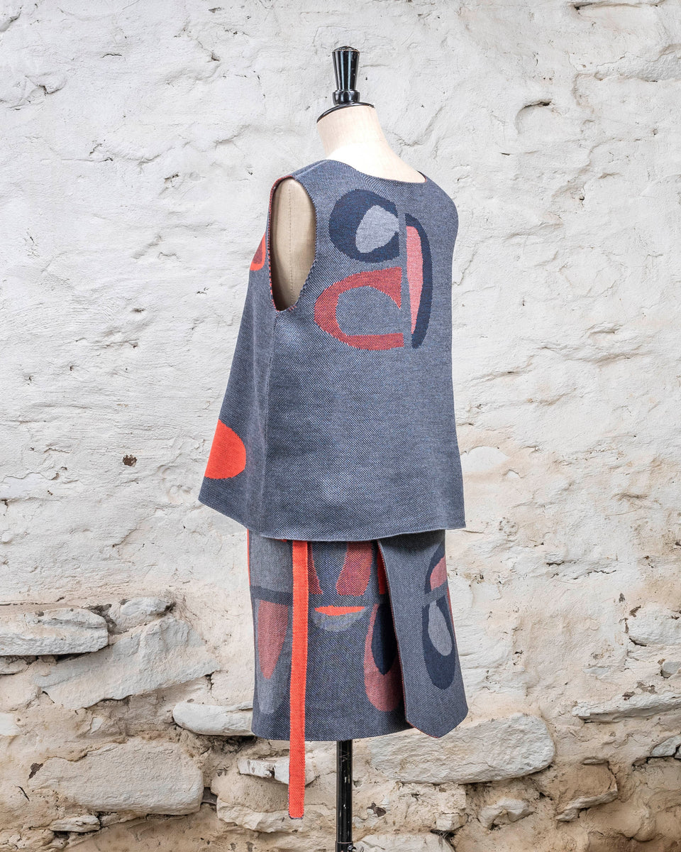 Knitted wrap skirt in blues with accents in coral. The pattern is abstract. Shown with tanque in same pattern.