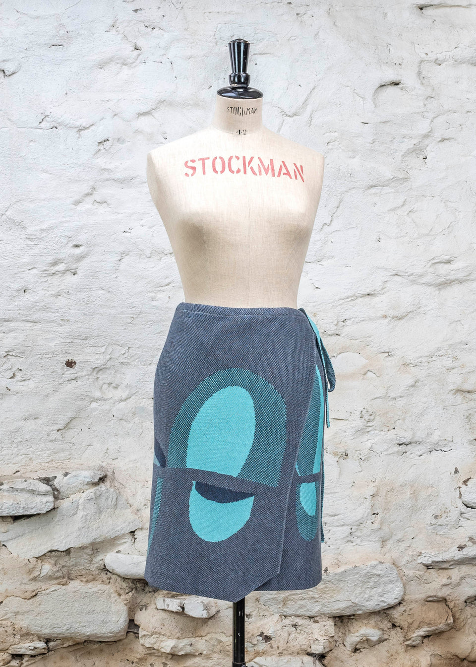 Knitted wrap skirt in blues with accents in aqua. The pattern is abstract
