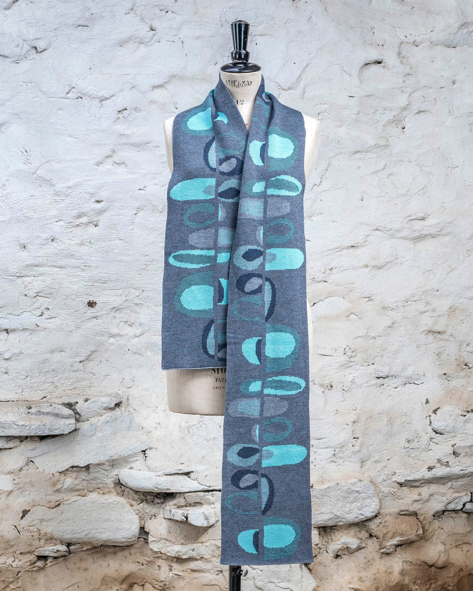 Knitted scarf in blues with accents in aqua. The pattern is abstract