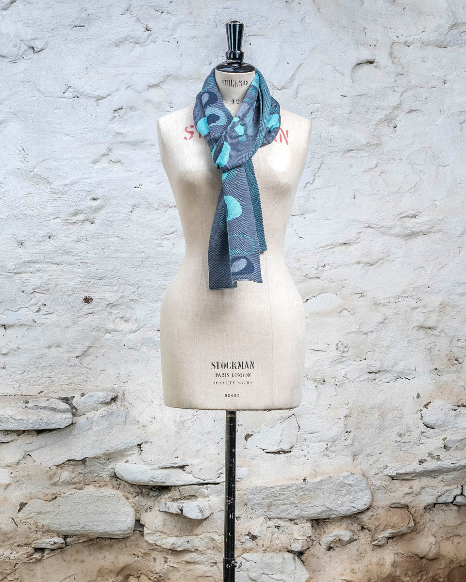 Knitted scarf in blues with accents in aqua. The pattern is abstract