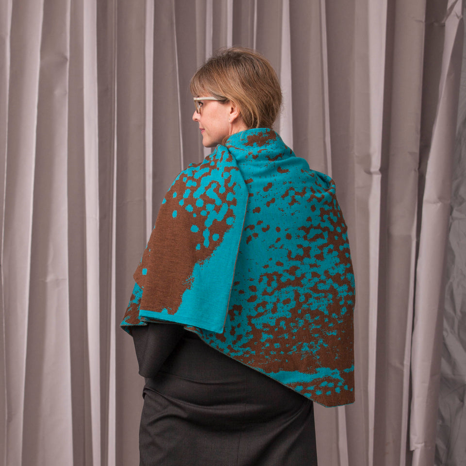 Knitted marlet wrap. Mottled animal print design show in in aqua and bronze