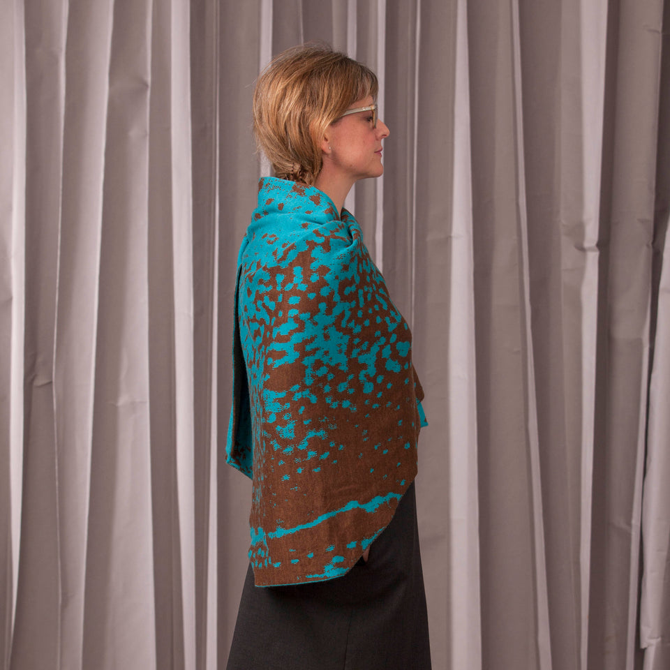 Knitted marlet wrap. Mottled animal print design show in in aqua and bronze