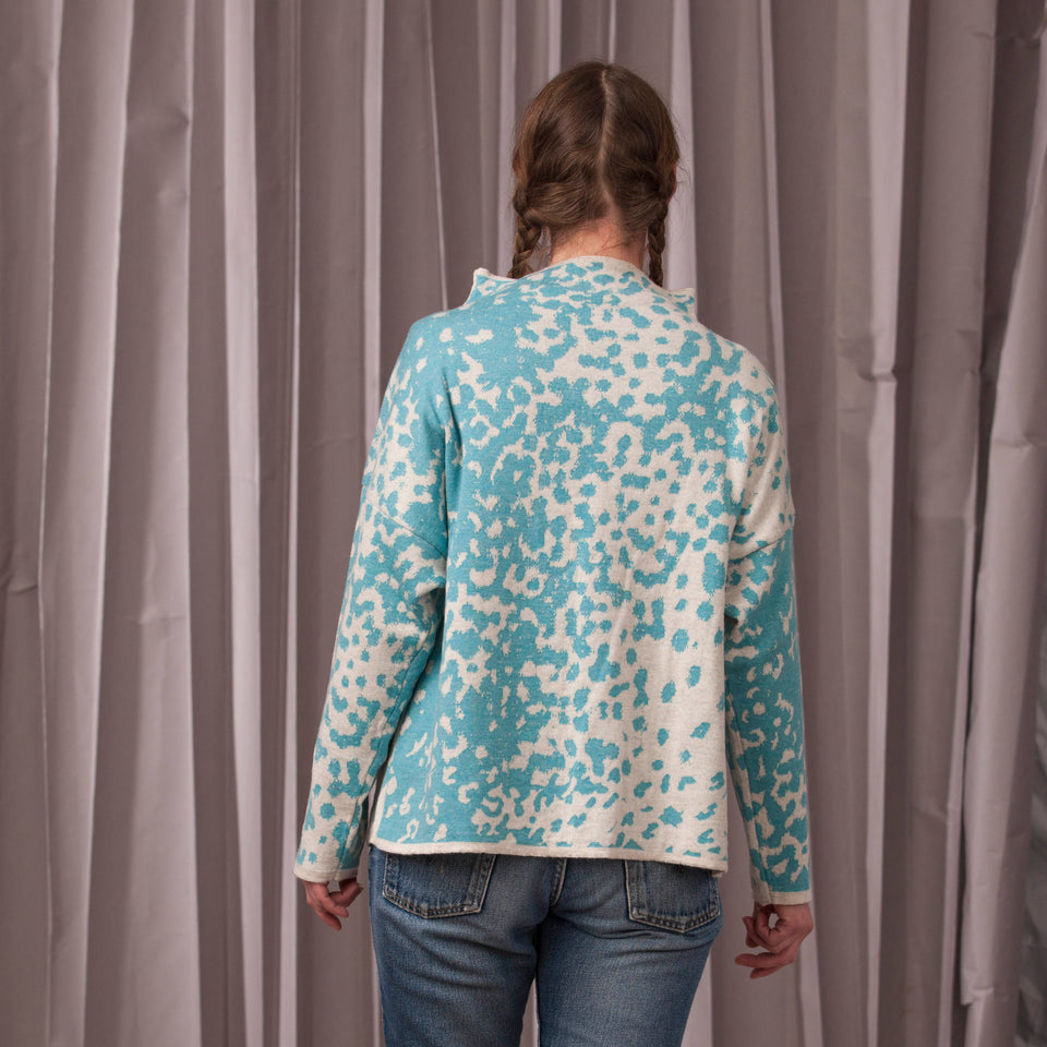 Knitted marlet jumper. Mottled animal print abstract pattern shown in turquoise and white