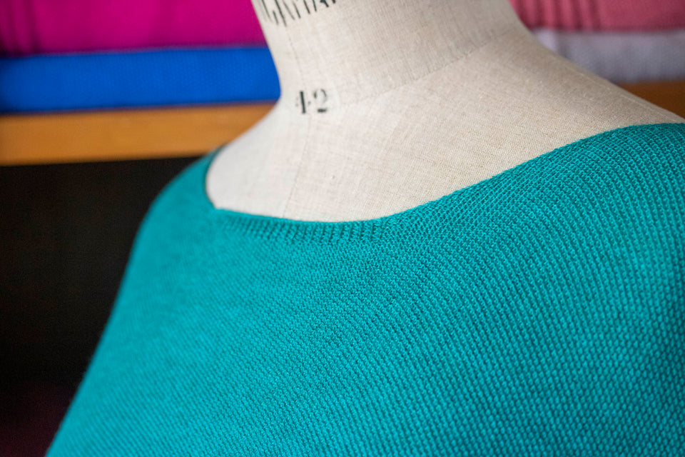 Knitted Saand jumper. contemporary sweater design in a boxy but flowing shape. Flat colour in a textured stitch. Shown in aqua. Neckline detail