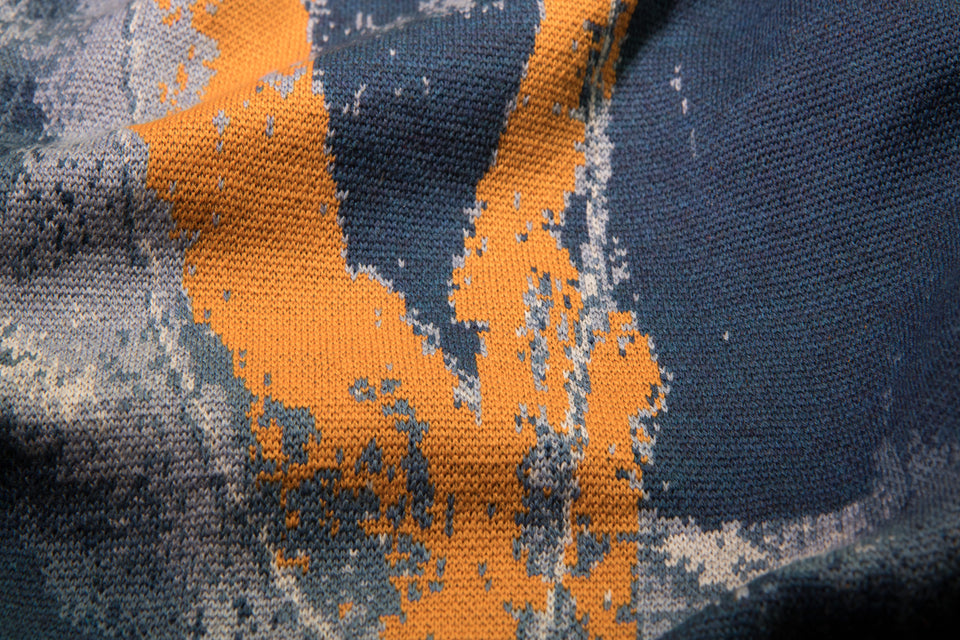 closeup up finely knitted Hoswick Paint jumper - abstract, shaded pattern in blues with orange highlights