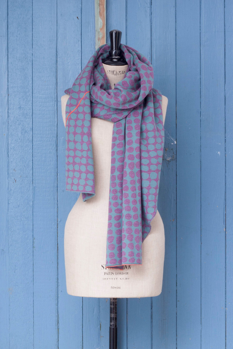 Knitted ebb-stanes wrap with irregular dot pattern shown in dark lilac and blue